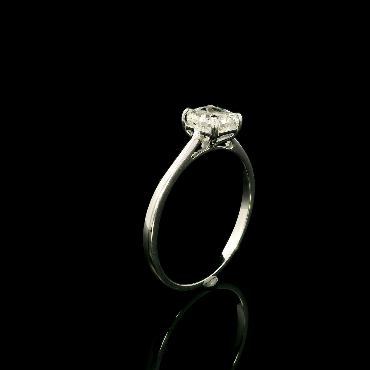 Radiant cut diamond solitaire engagement ring in 18K white gold with a four-prong setting and polished band.