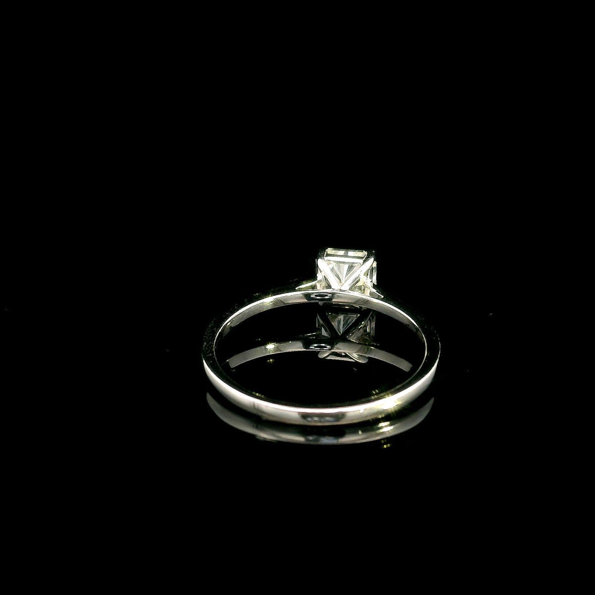 Radiant cut diamond solitaire engagement ring in 18K white gold with a four-prong setting and polished band.