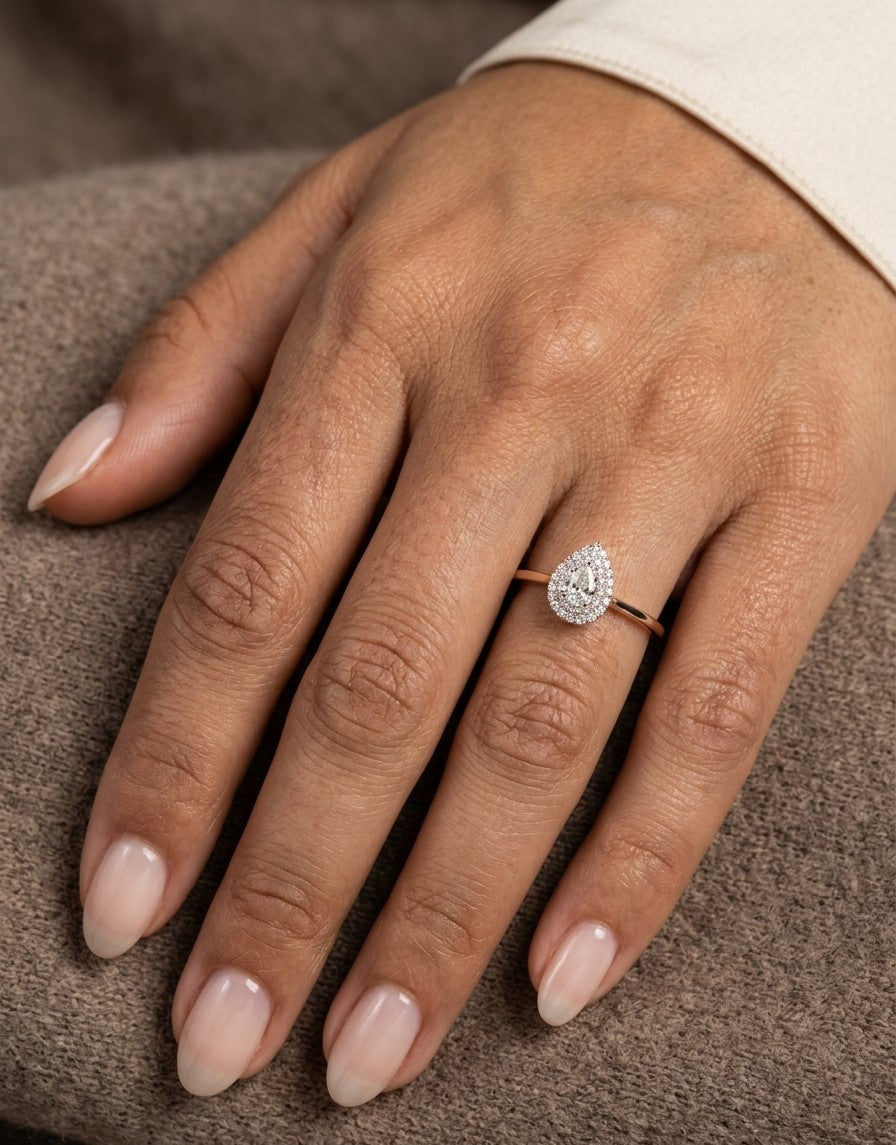 Pear shaped diamond halo ring in 18K white gold with round diamond halo