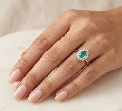 18K white gold pear shaped emerald and diamond halo ring with green emerald surrounded by round diamonds