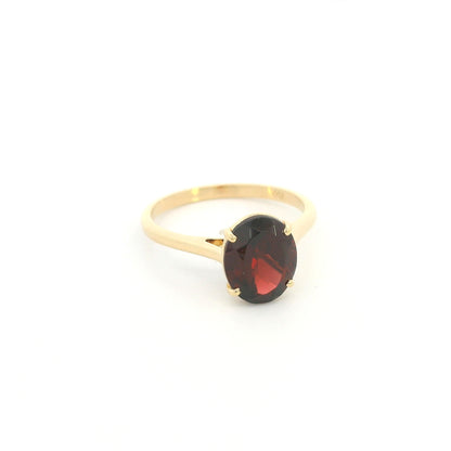 Oval garnet solitaire ring in 18K yellow gold