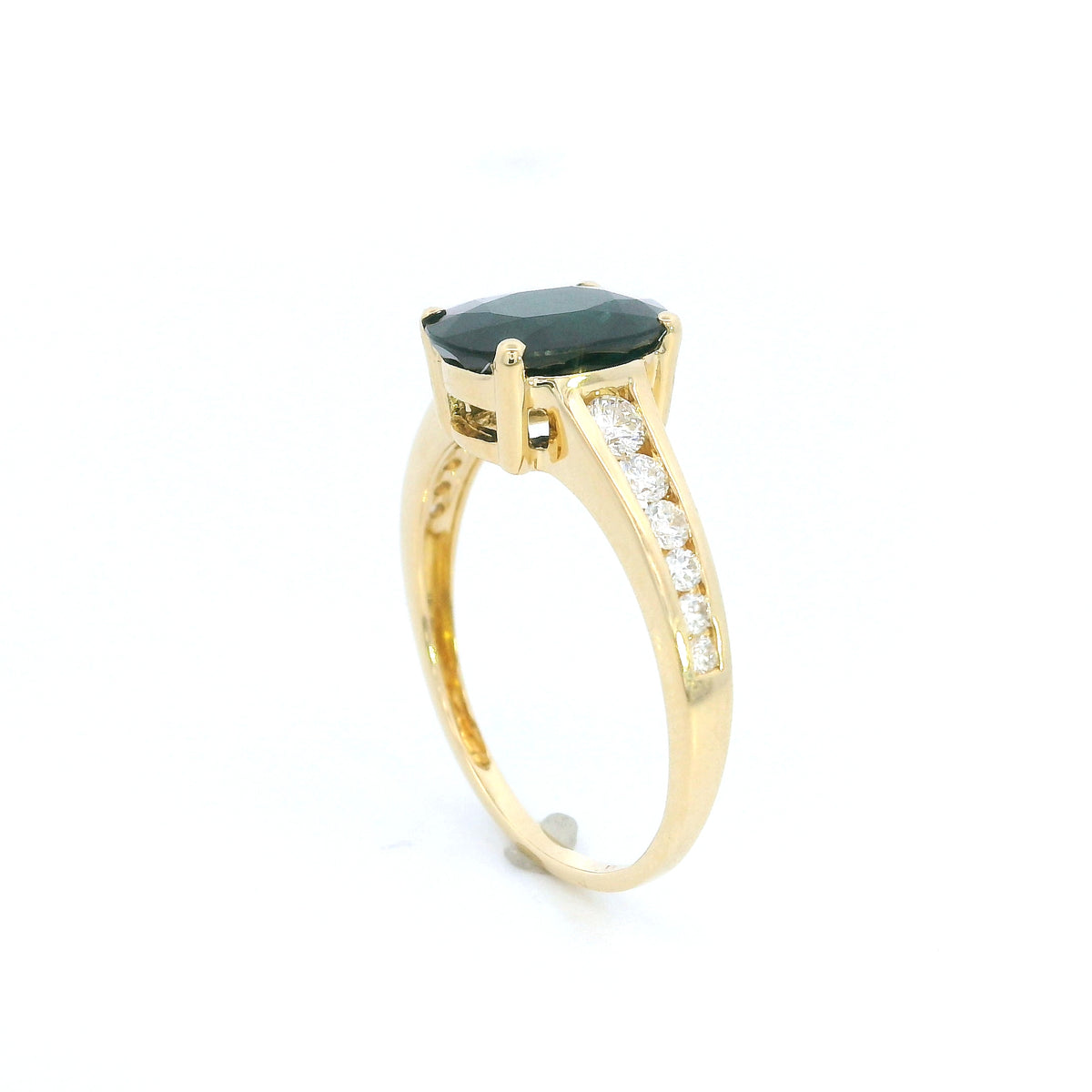 Blue sapphire and diamond ring in 18K yellow gold featuring an oval blue sapphire with round brilliant diamond-set shoulders.