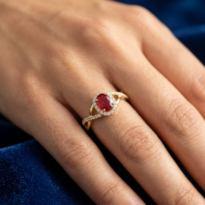 Ruby and diamond ring in 18K yellow gold with oval ruby, diamond halo and crossover band