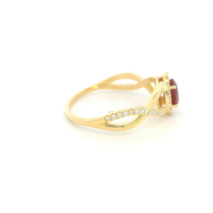 Ruby and diamond ring in 18K yellow gold with oval ruby, diamond halo and crossover band
