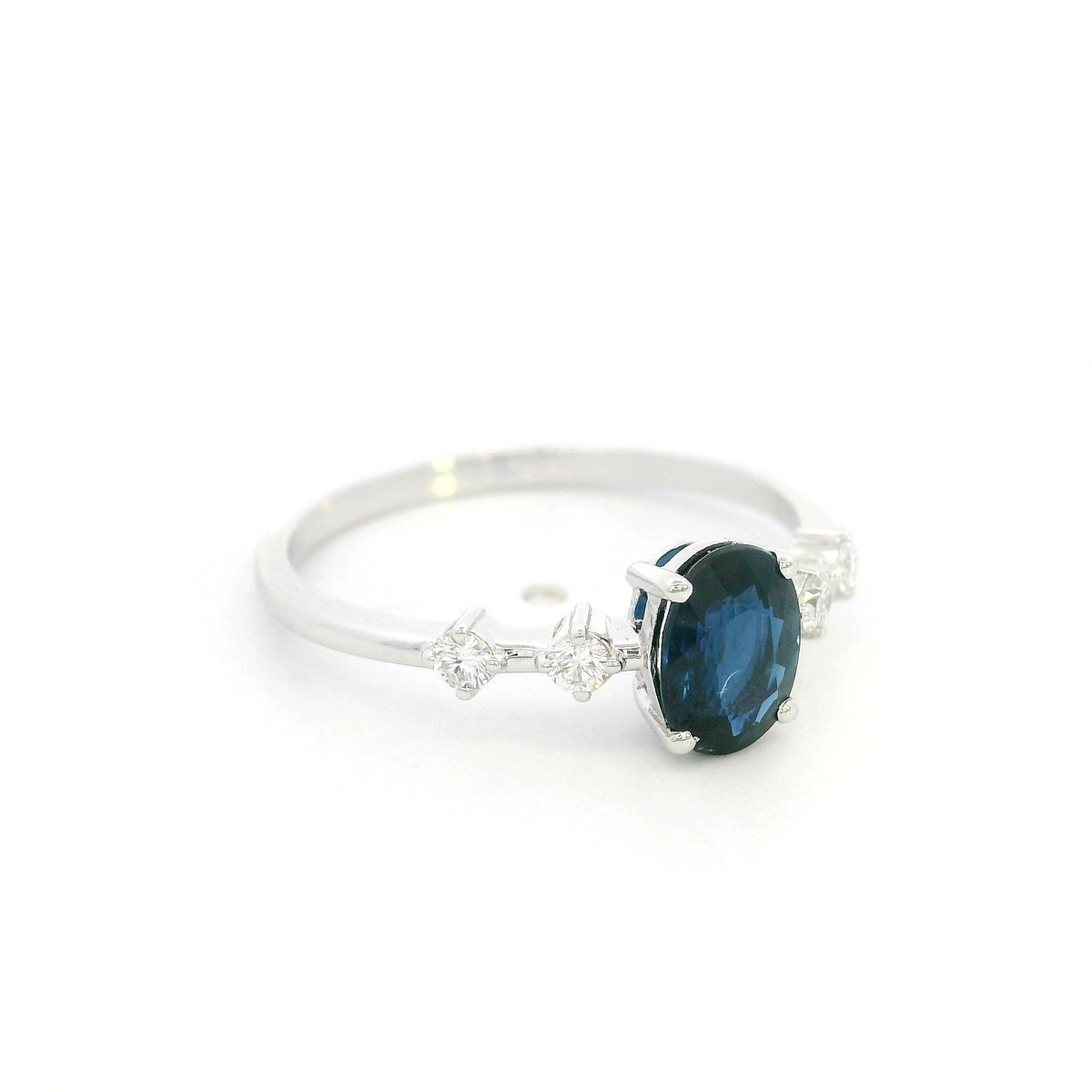 Oval blue sapphire diamond ring in 18K white gold with round diamond side stones
