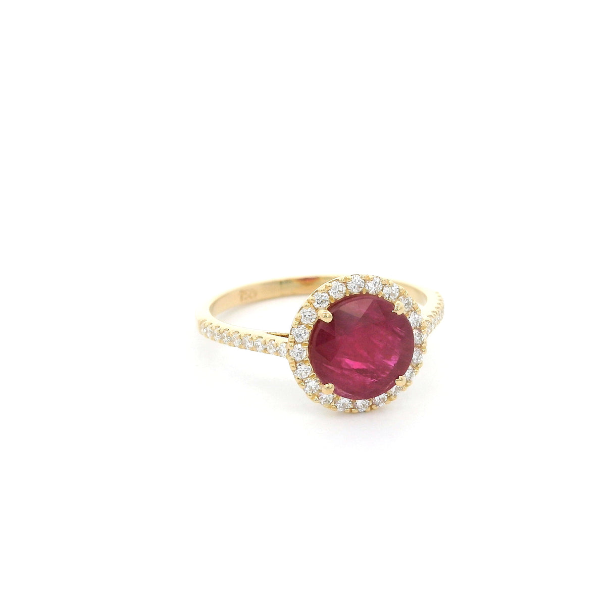 Ruby and diamond halo ring in 18K yellow gold featuring a round red ruby surrounded by diamonds with diamond-set shoulders.