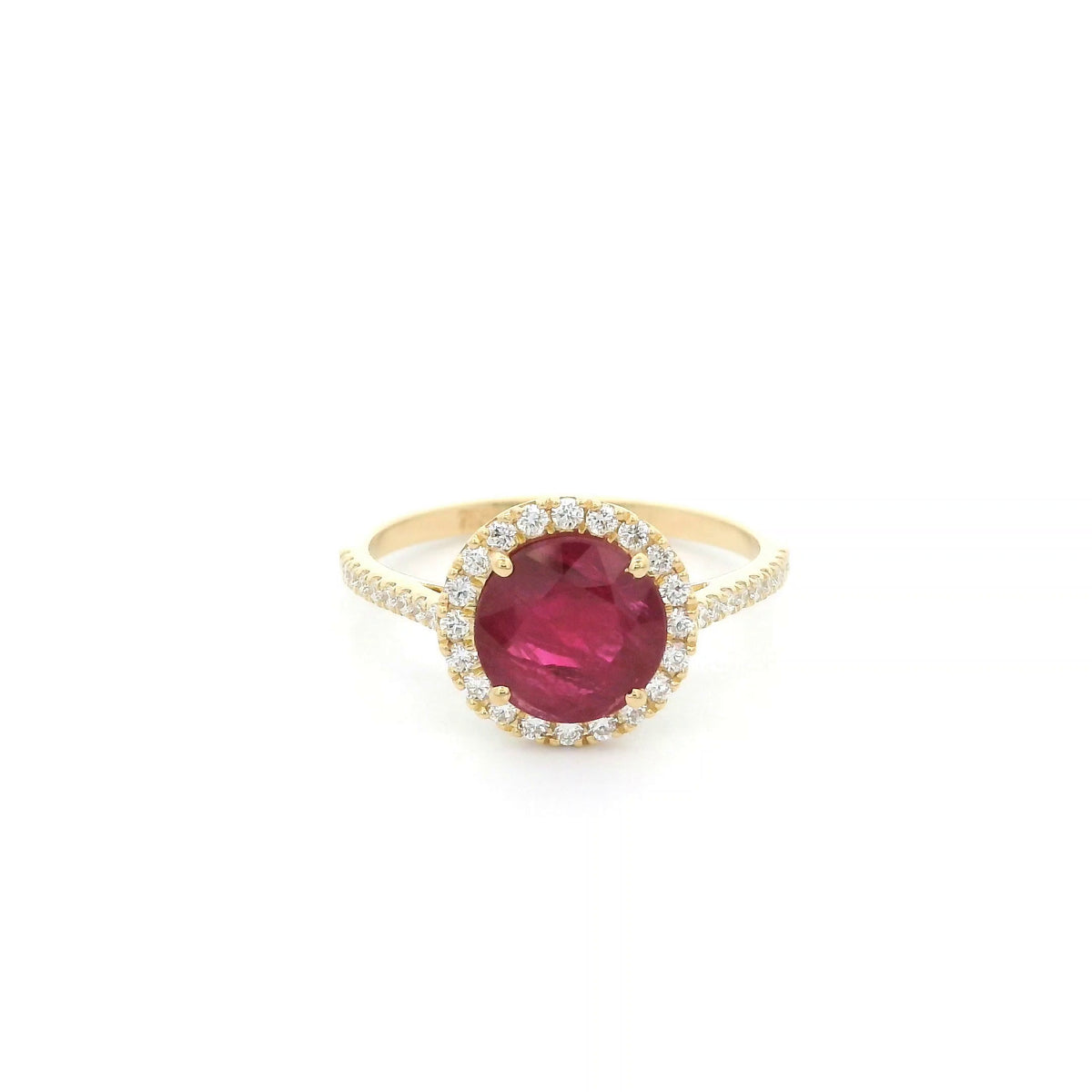 Ruby and diamond halo ring in 18K yellow gold featuring a round red ruby surrounded by diamonds with diamond-set shoulders.
