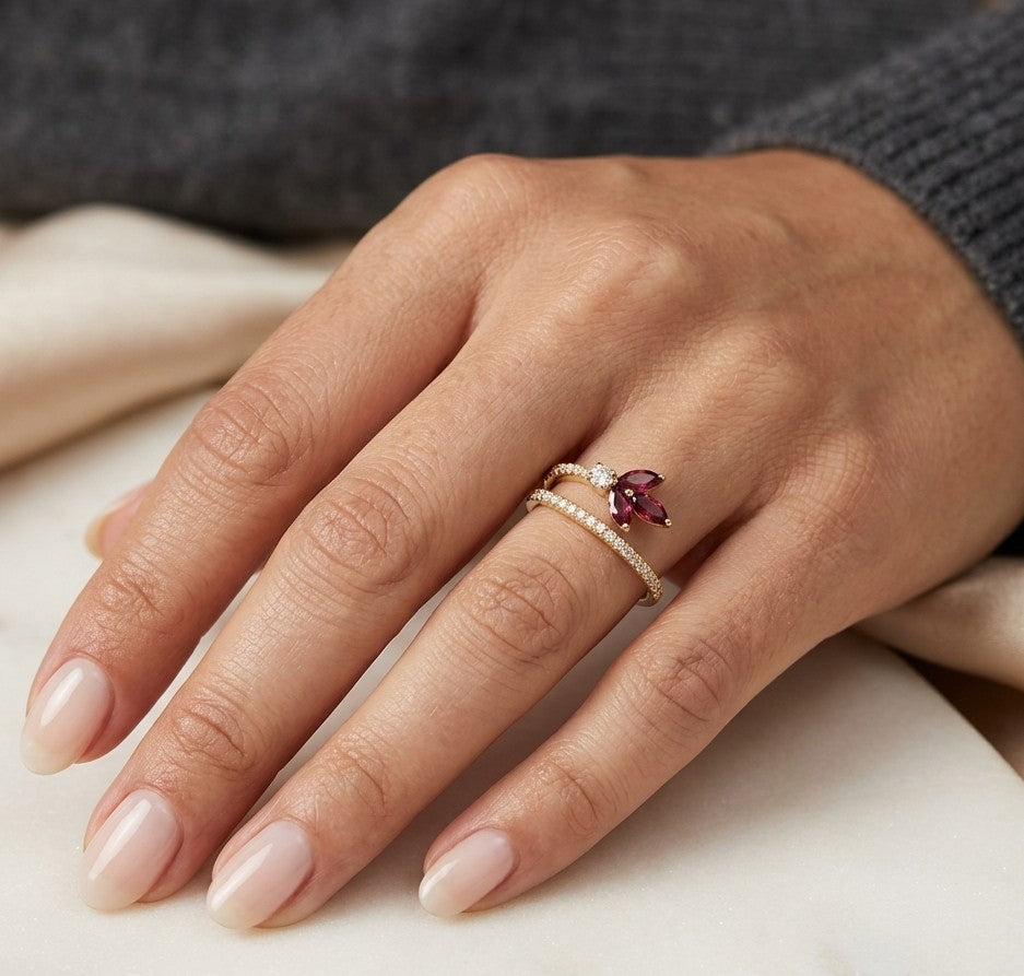 Ruby and diamond floral ring in 18K yellow gold with three marquise shaped rubies and sweeping diamond-set bands.