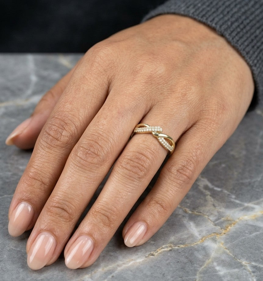 Diamond crossover ring in 18K yellow gold with polished and pavé diamond twist design