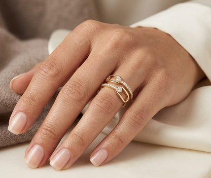 Diamond open bypass ring in 18K yellow gold with round diamonds, sweeping diamond-set curves and polished gold loops.