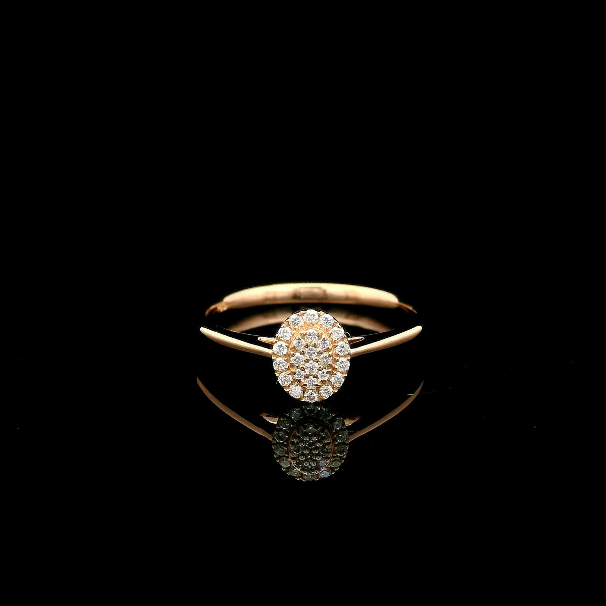 Oval diamond cluster ring in 18K rose gold with round diamonds and a slim polished band.