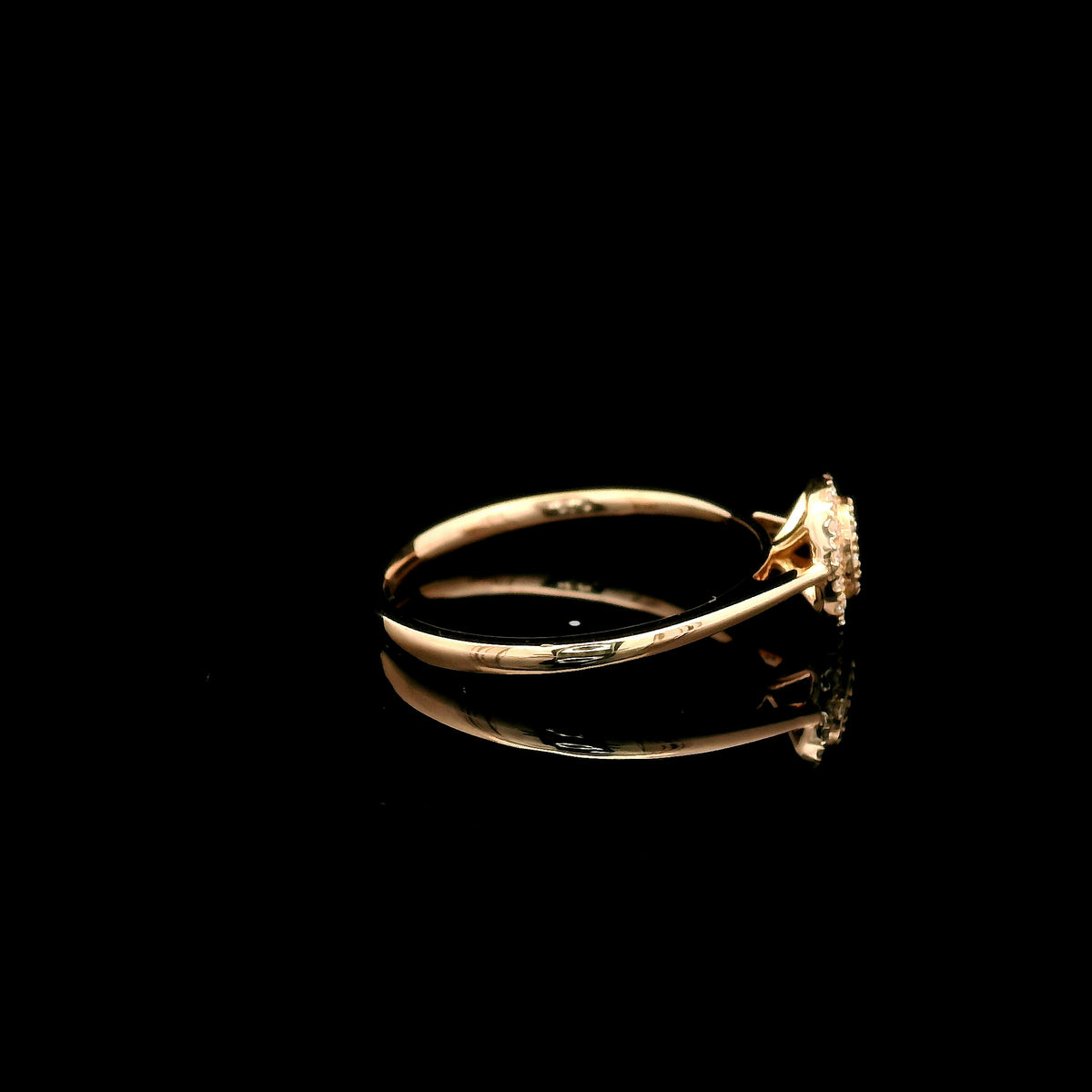 Oval diamond cluster ring in 18K rose gold with round diamonds and a slim polished band.