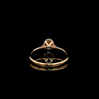 Oval diamond cluster ring in 18K rose gold with round diamonds and a slim polished band.