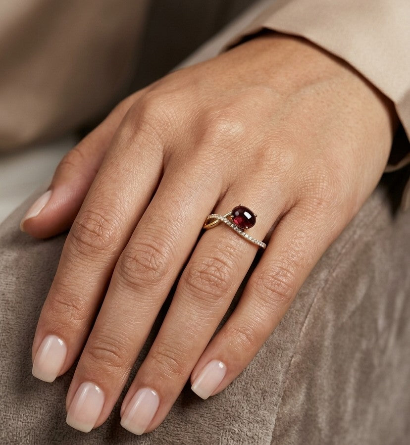 Oval cabochon ruby and diamond ring in 18K yellow gold with curved crossover band