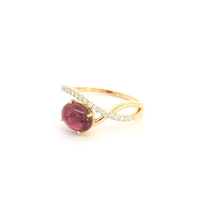 Oval cabochon ruby and diamond ring in 18K yellow gold with curved crossover band