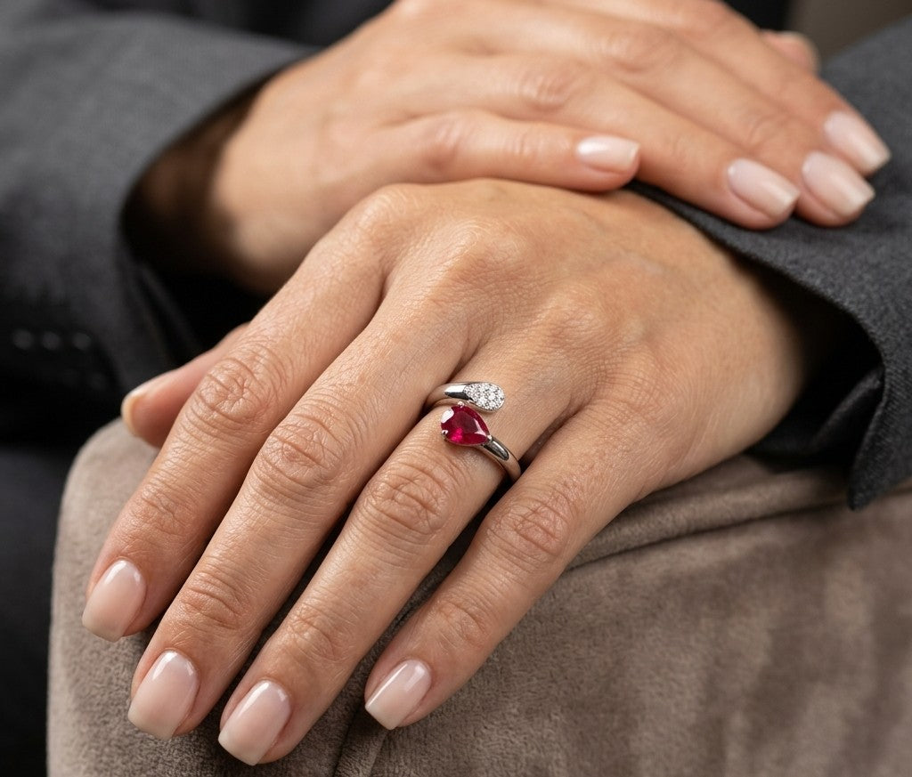 Pear shaped ruby and diamond bypass ring in 18K white gold with open teardrop design