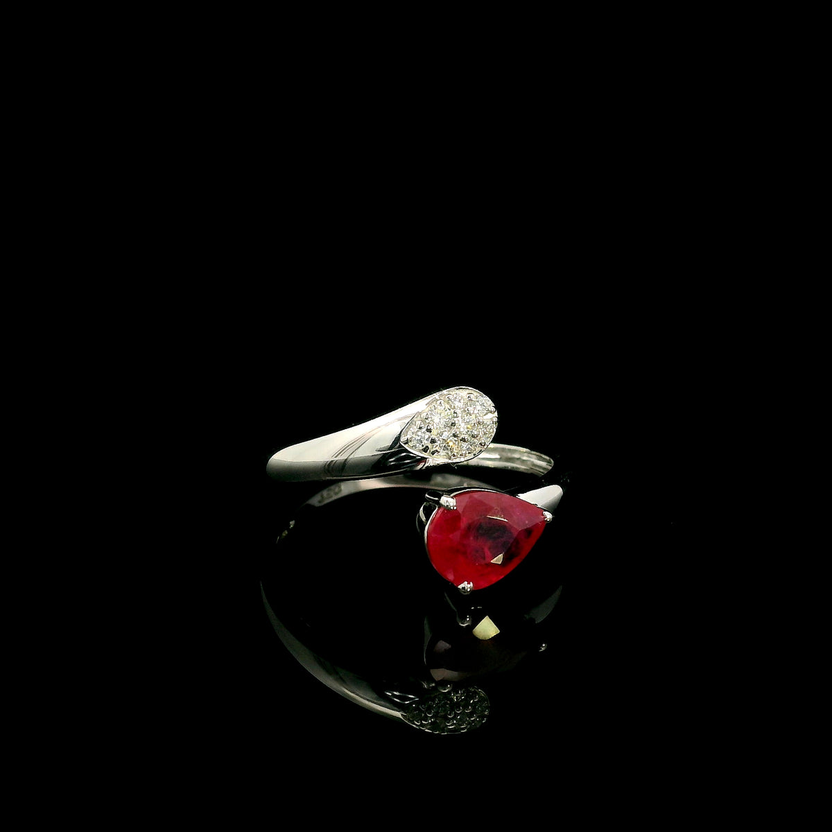 Pear shaped ruby and diamond bypass ring in 18K white gold with open teardrop design