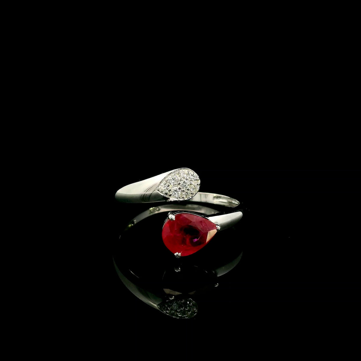 Pear shaped ruby and diamond bypass ring in 18K white gold with open teardrop design