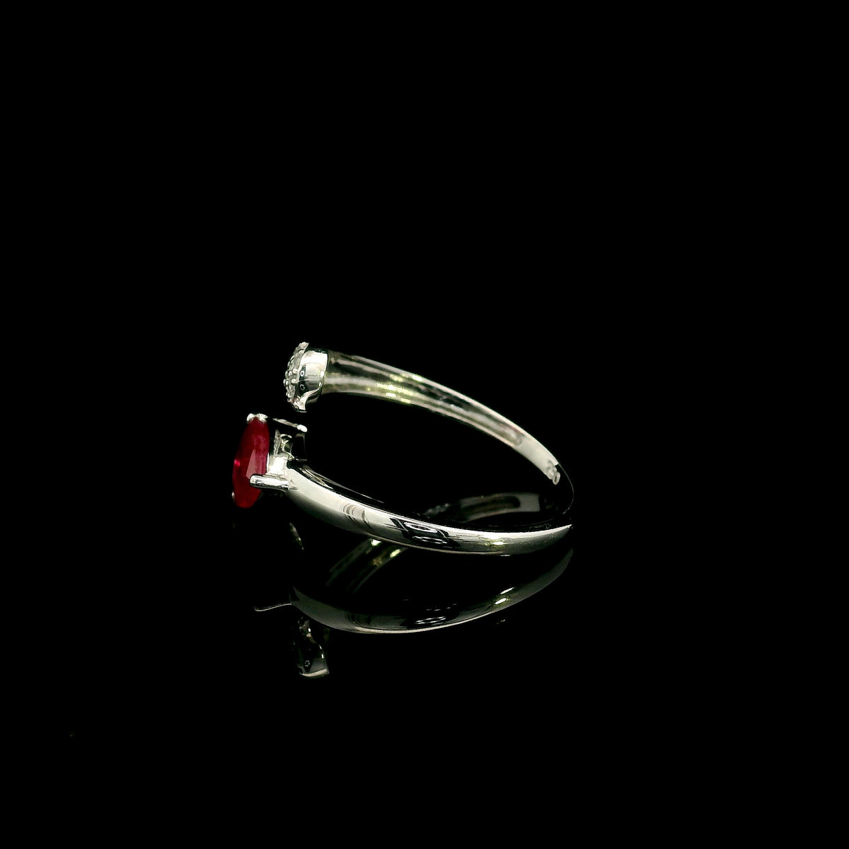 Pear shaped ruby and diamond bypass ring in 18K white gold with open teardrop design
