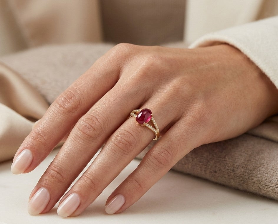 Oval cabochon ruby and diamond ring in 18K yellow gold with diamond-set split shoulders.