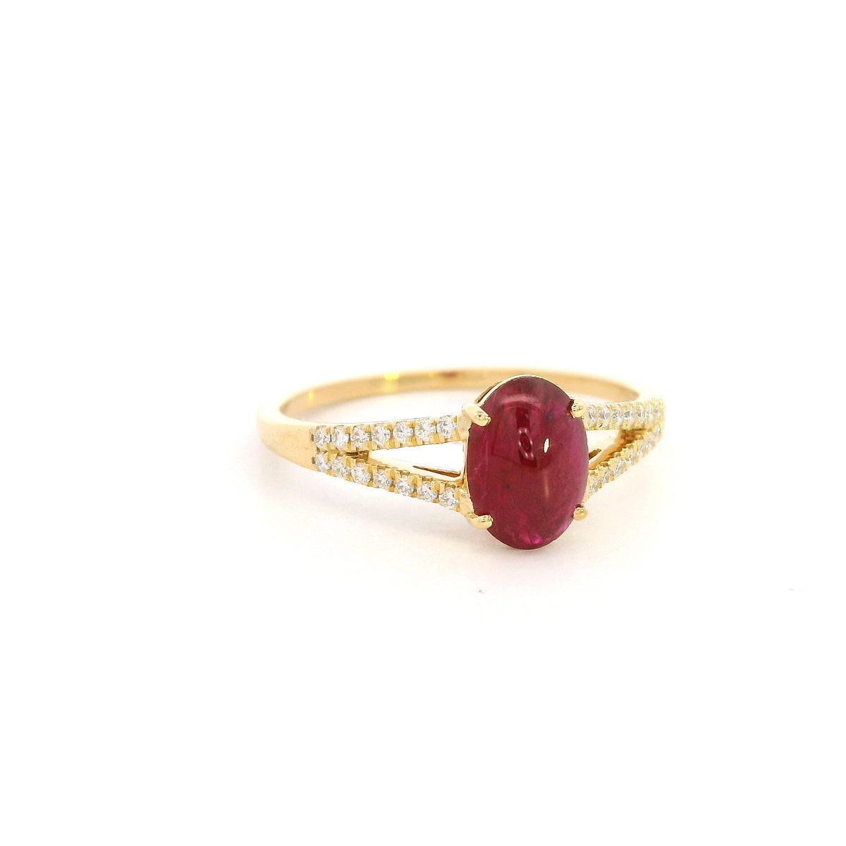 Oval cabochon ruby and diamond ring in 18K yellow gold with diamond-set split shoulders.