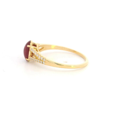 Oval cabochon ruby and diamond ring in 18K yellow gold with diamond-set split shoulders.