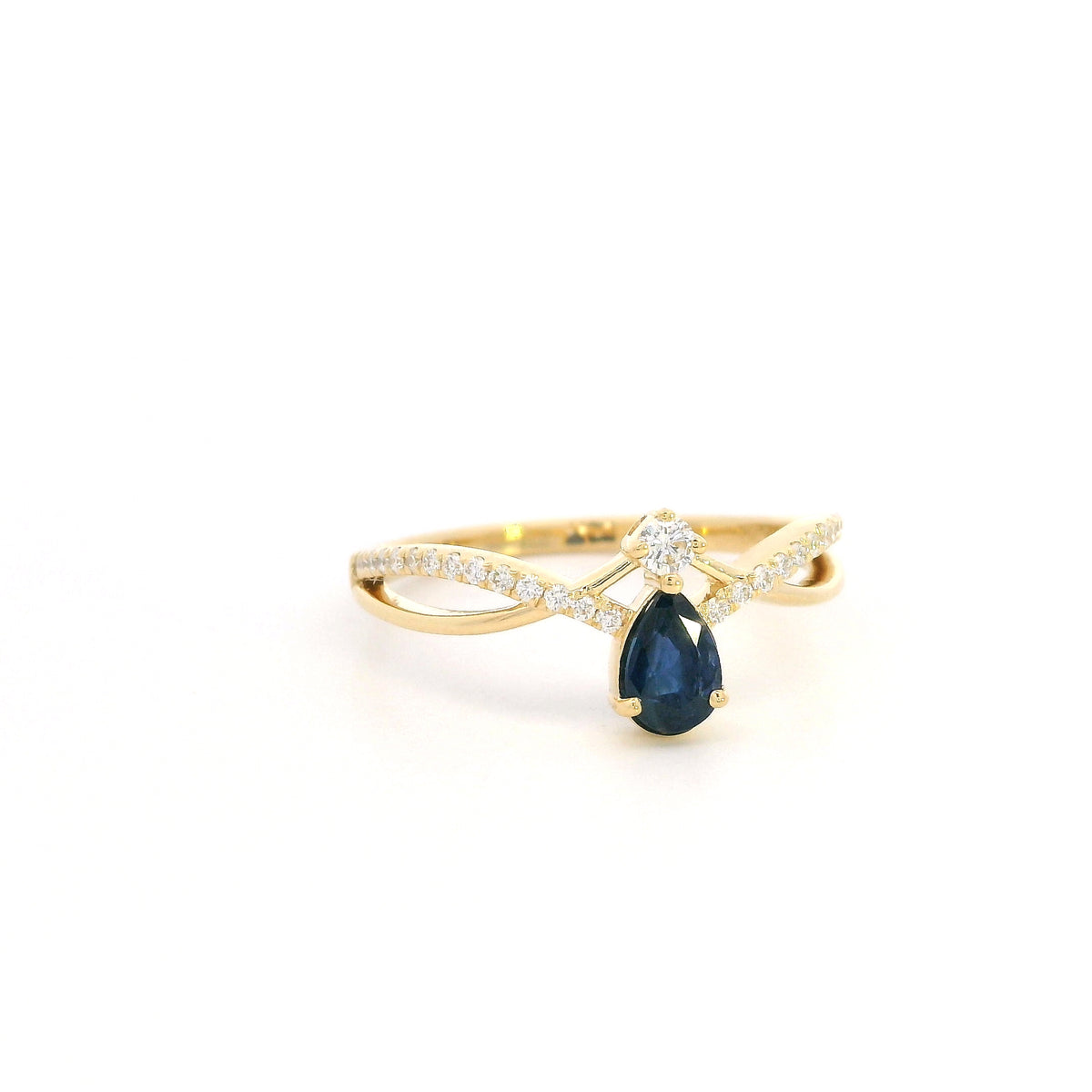 Pear shaped blue sapphire and diamond ring in 18K yellow gold with sweeping diamond-set design.