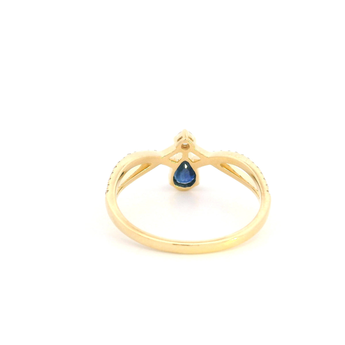 Pear shaped blue sapphire and diamond ring in 18K yellow gold with sweeping diamond-set design.