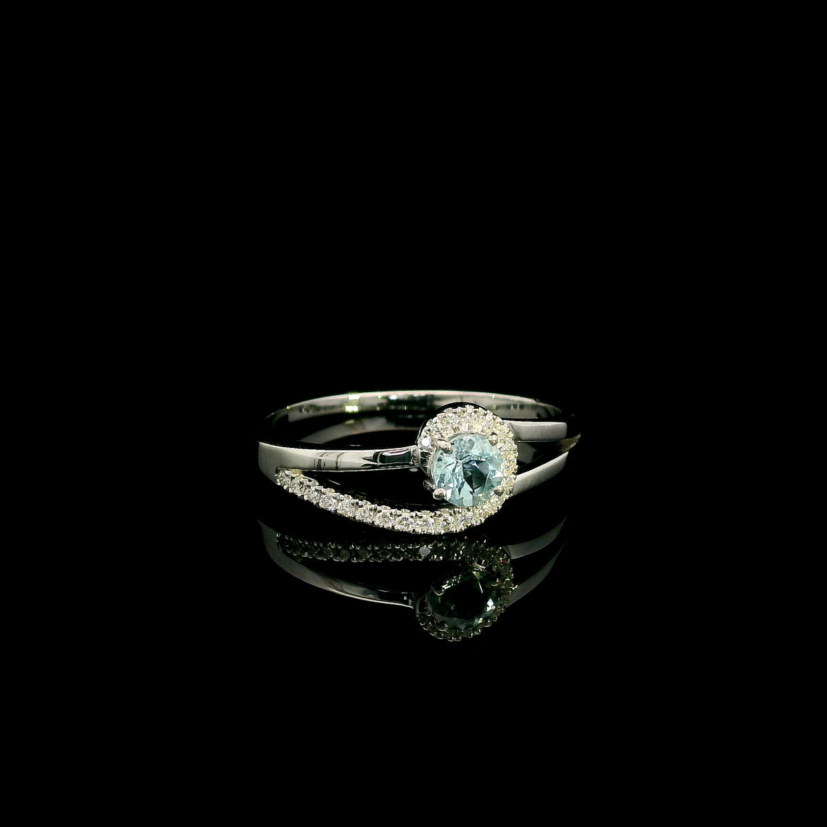 18K white gold ring with a round cut aquamarine, a curved row of diamonds wrapping around the gemstone and a polished gold band.