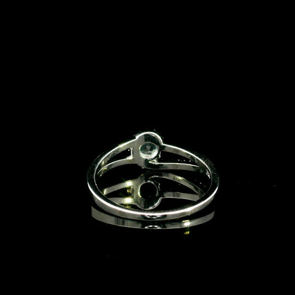 18K white gold ring with a round cut aquamarine, a curved row of diamonds wrapping around the gemstone and a polished gold band.