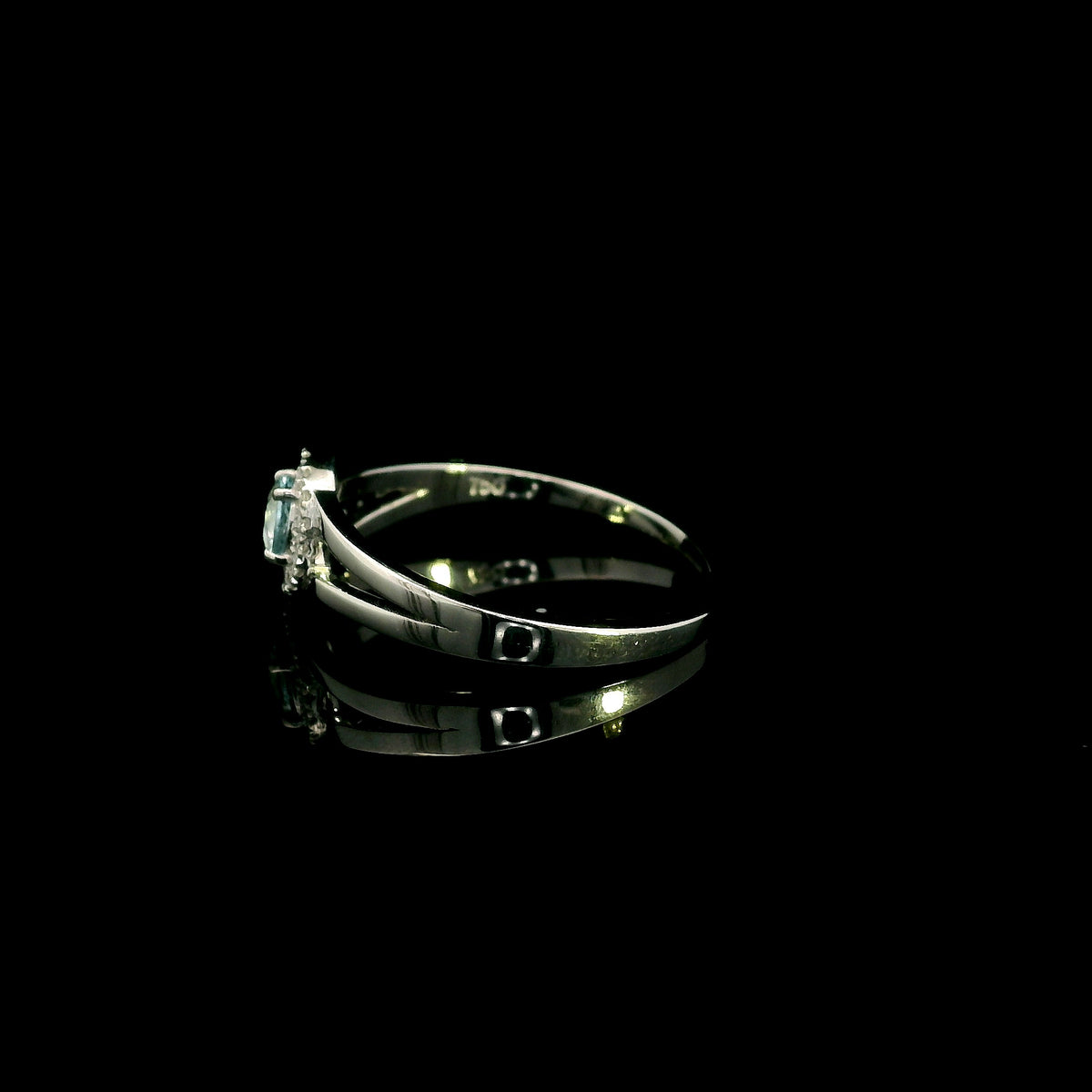 18K white gold ring with a round cut aquamarine, a curved row of diamonds wrapping around the gemstone and a polished gold band.