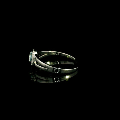 18K white gold ring with a round cut aquamarine, a curved row of diamonds wrapping around the gemstone and a polished gold band.