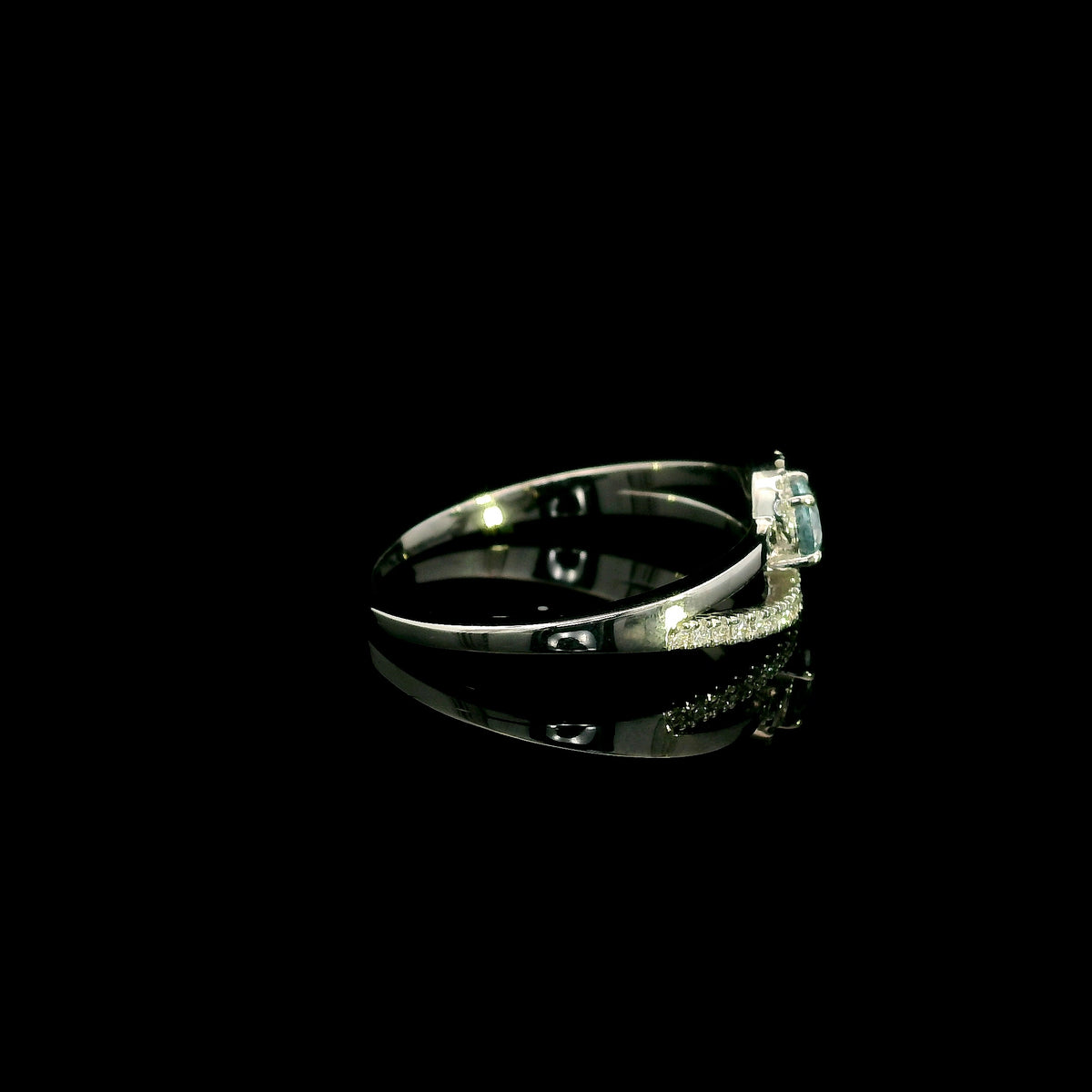 18K white gold ring with a round cut aquamarine, a curved row of diamonds wrapping around the gemstone and a polished gold band.