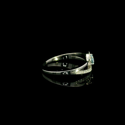 18K white gold ring with a round cut aquamarine, a curved row of diamonds wrapping around the gemstone and a polished gold band.