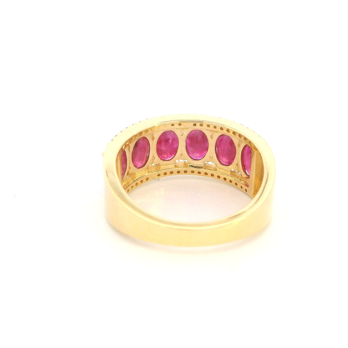 Oval ruby and diamond band ring in 18K yellow gold with a row of rubies framed by round diamonds.