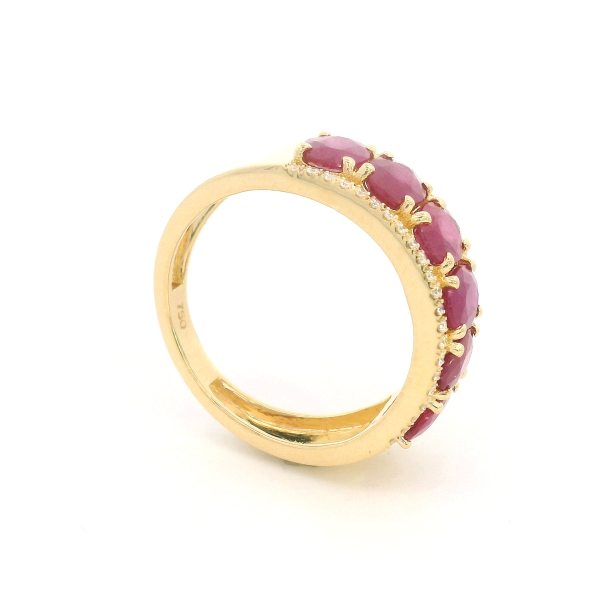 Oval ruby and diamond band ring in 18K yellow gold with a row of rubies framed by round diamonds.