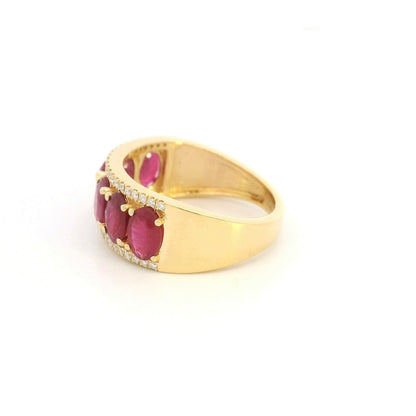 Oval ruby and diamond band ring in 18K yellow gold with a row of rubies framed by round diamonds.