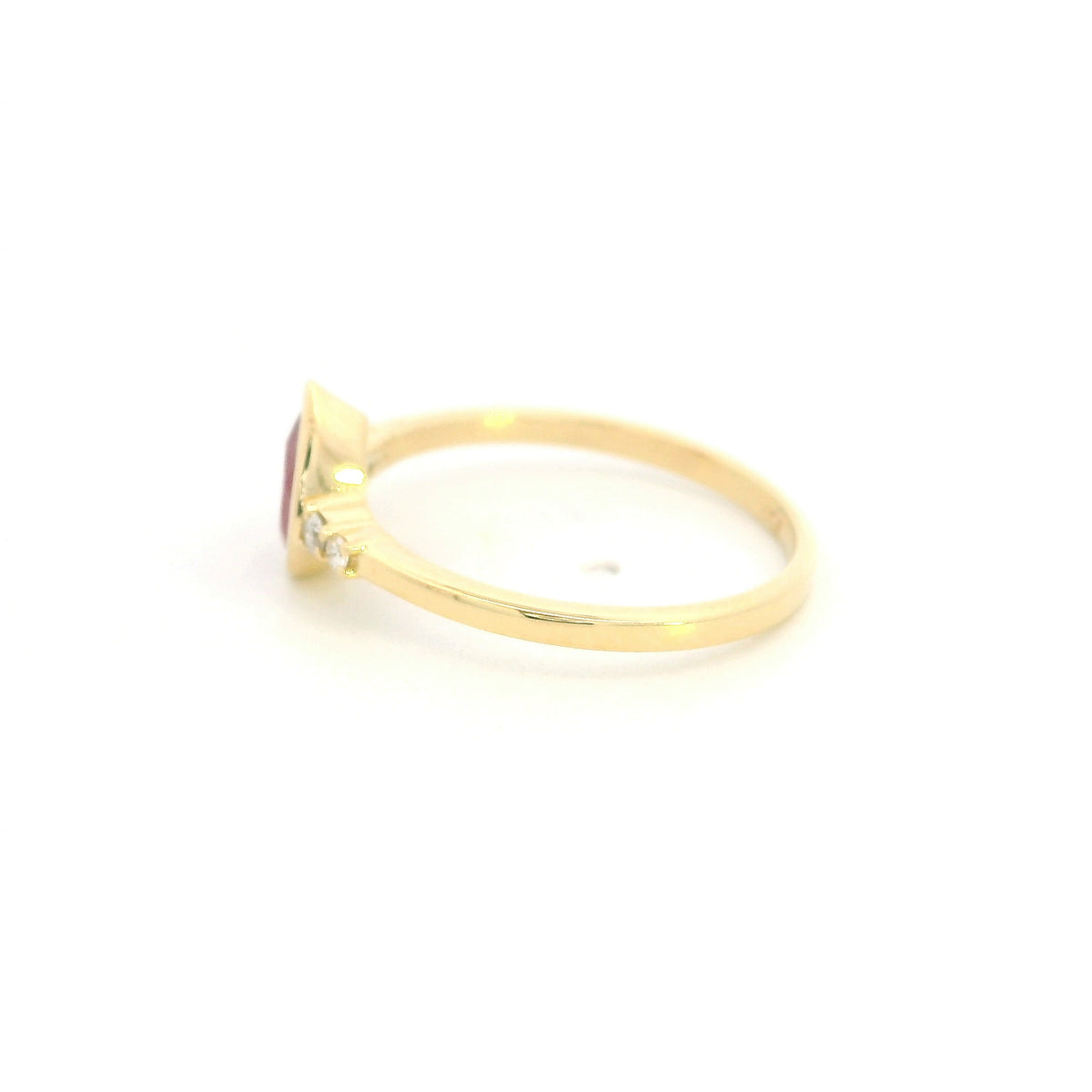 Pear-shaped red ruby ring in 18K yellow gold with a smooth bezel setting and small round diamonds along both shoulders.