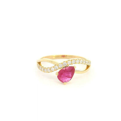 Pear shaped ruby and diamond ring in 18K yellow gold featuring a sweeping diamond-set curved band and asymmetrical design.