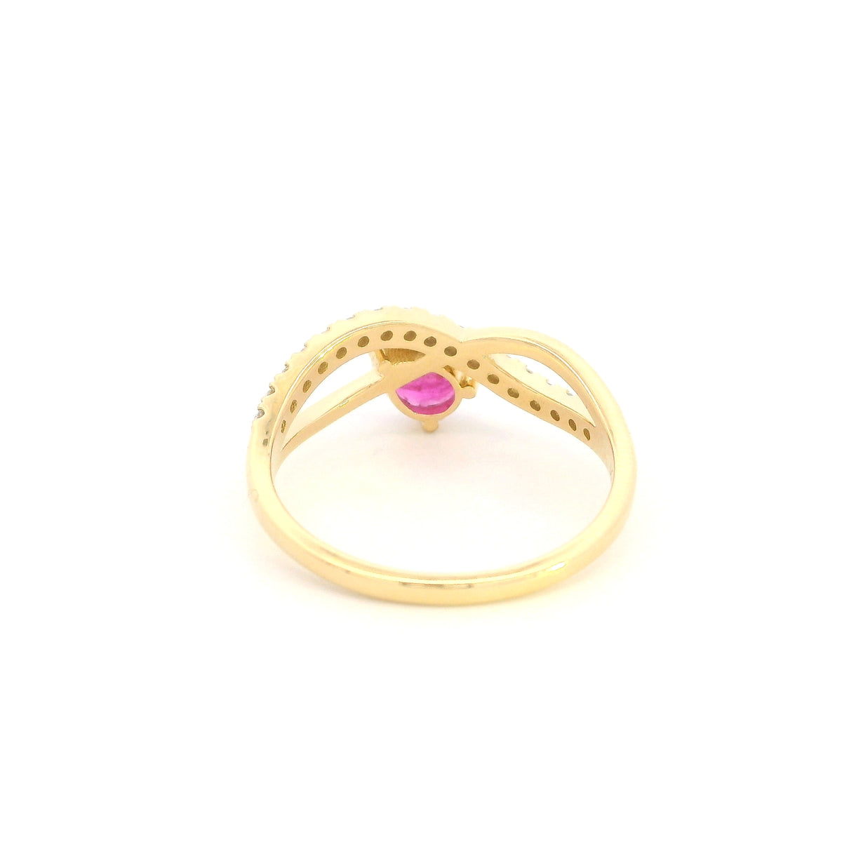 Pear shaped ruby and diamond ring in 18K yellow gold featuring a sweeping diamond-set curved band and asymmetrical design.