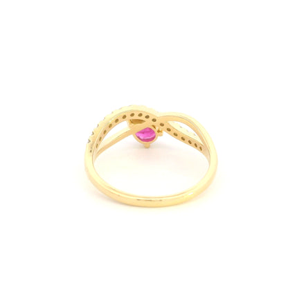 Pear shaped ruby and diamond ring in 18K yellow gold featuring a sweeping diamond-set curved band and asymmetrical design.