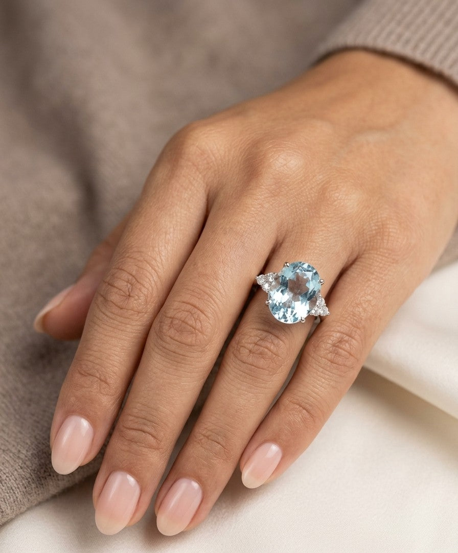 Oval aquamarine and diamond statement ring in 18K white gold with diamond side accents