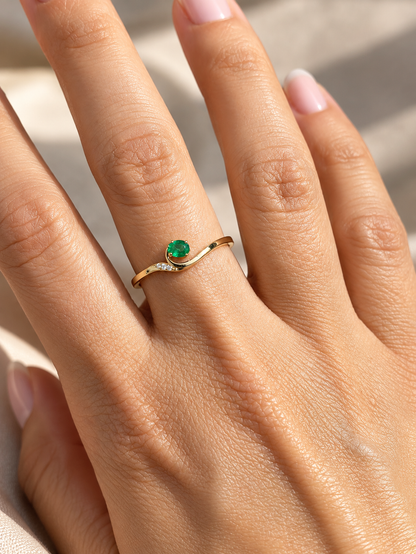 Dainty emerald and diamond ring in 18K yellow gold with curved asymmetrical design