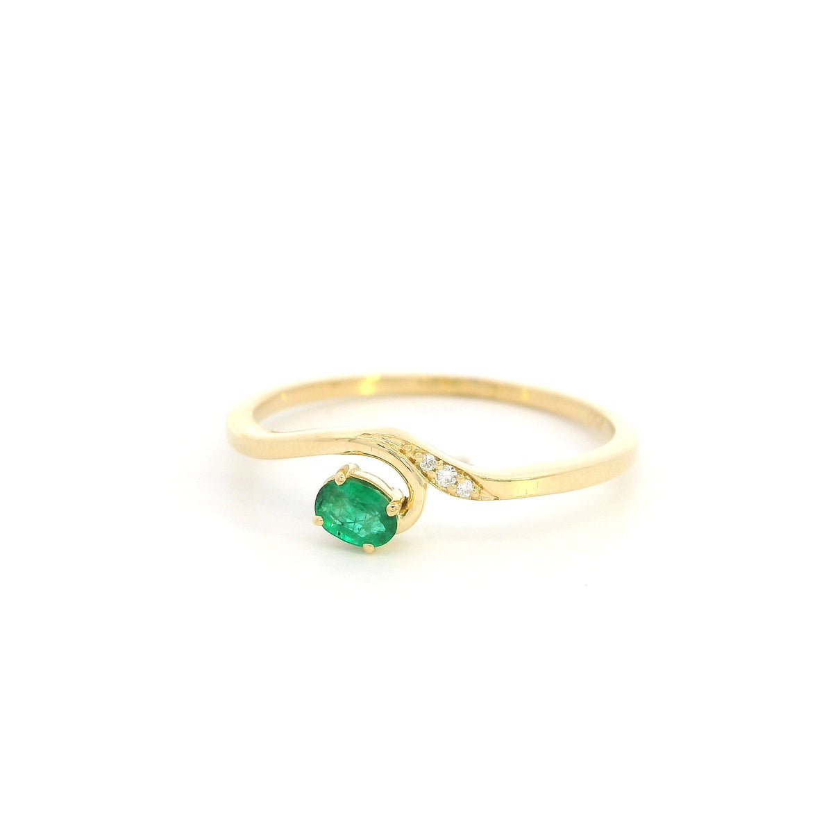 Dainty emerald and diamond ring in 18K yellow gold with curved asymmetrical design