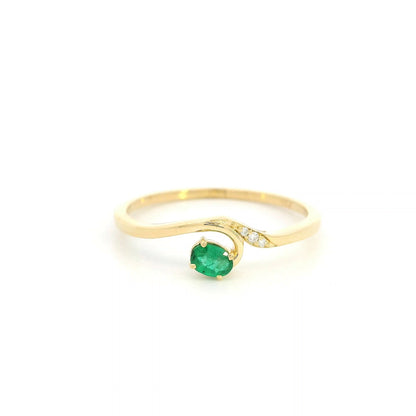 Dainty emerald and diamond ring in 18K yellow gold with curved asymmetrical design
