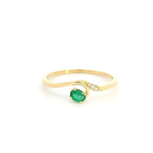 Dainty emerald and diamond ring in 18K yellow gold with curved asymmetrical design