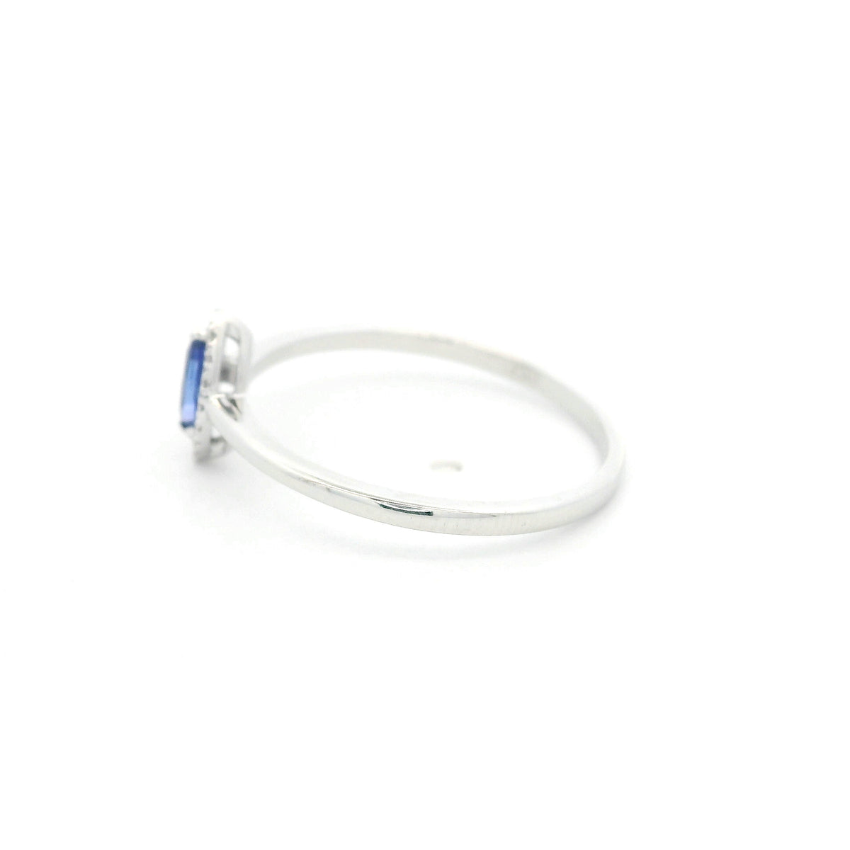 Dainty marquise tanzanite and diamond halo ring in 18K white gold with a slim polished band.