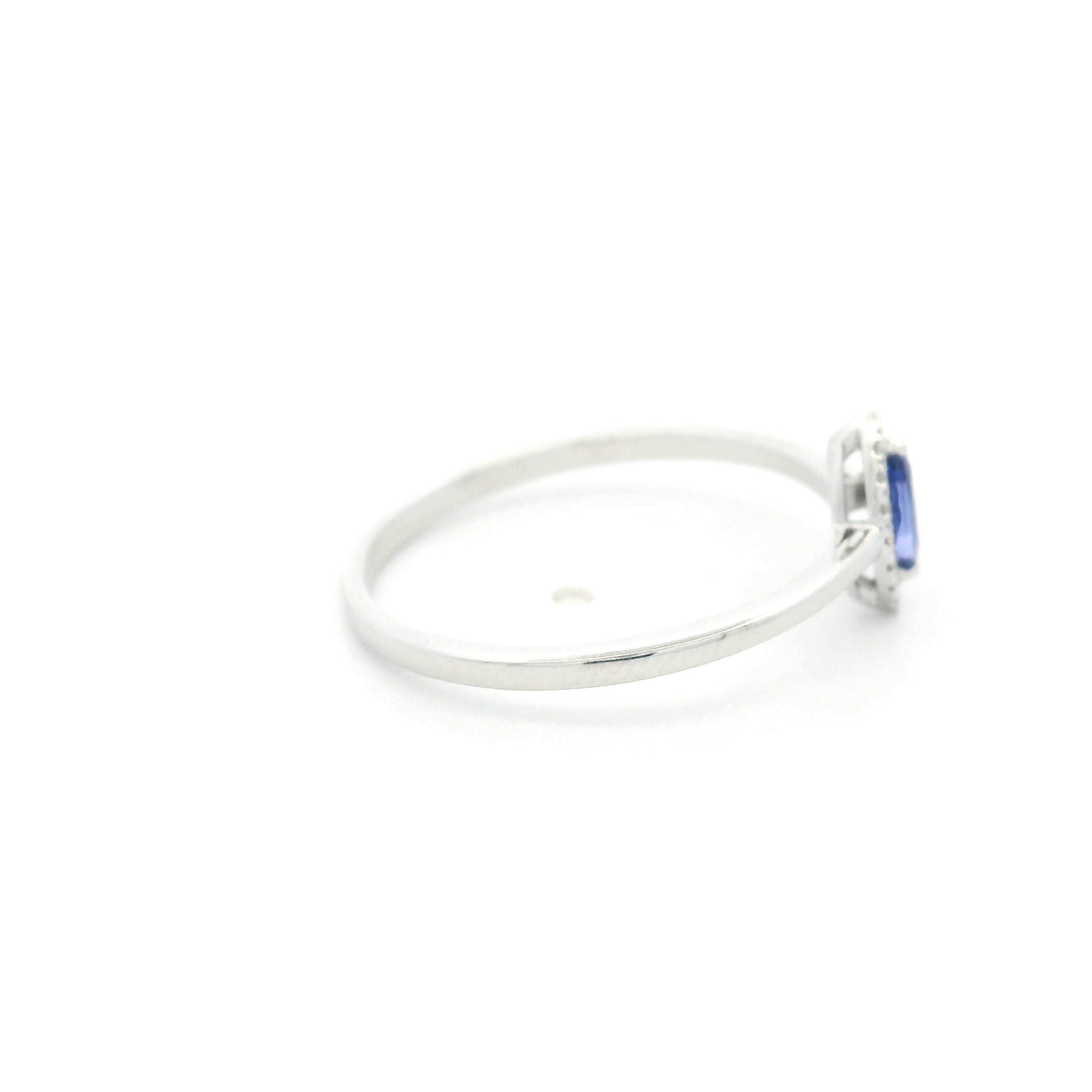 Dainty marquise tanzanite and diamond halo ring in 18K white gold with a slim polished band.