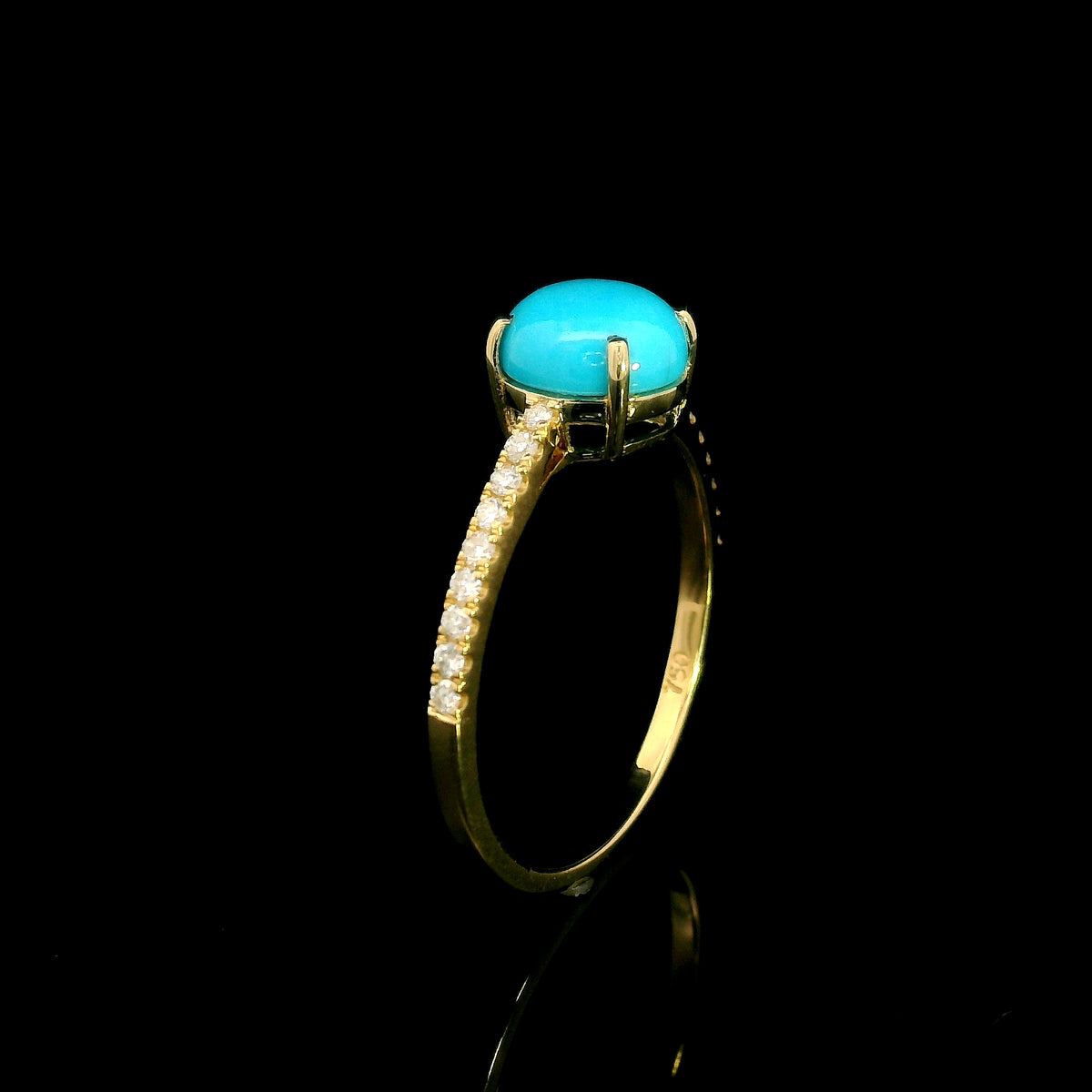 18K yellow gold turquoise and diamond ring featuring a round cabochon turquoise gemstone in a four-prong setting with round diamonds along the band.