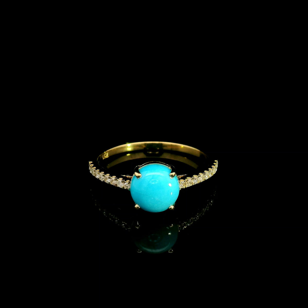 18K yellow gold turquoise and diamond ring featuring a round cabochon turquoise gemstone in a four-prong setting with round diamonds along the band.